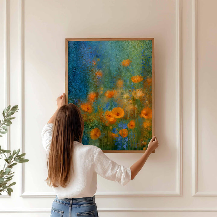 May include: A framed art print with an abstract floral design. The artwork displays orange flowers set against blue and green tones. The wooden frame enhances the vibrant colours of the painting, creating a visually appealing piece.