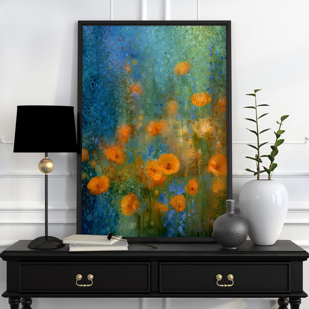 May include: A framed art print depicting orange poppies set against a blue and green backdrop. The artwork is displayed on a black table, alongside a black lamp, a white vase, and a small grey vase. The table has gold-coloured drawer pulls.