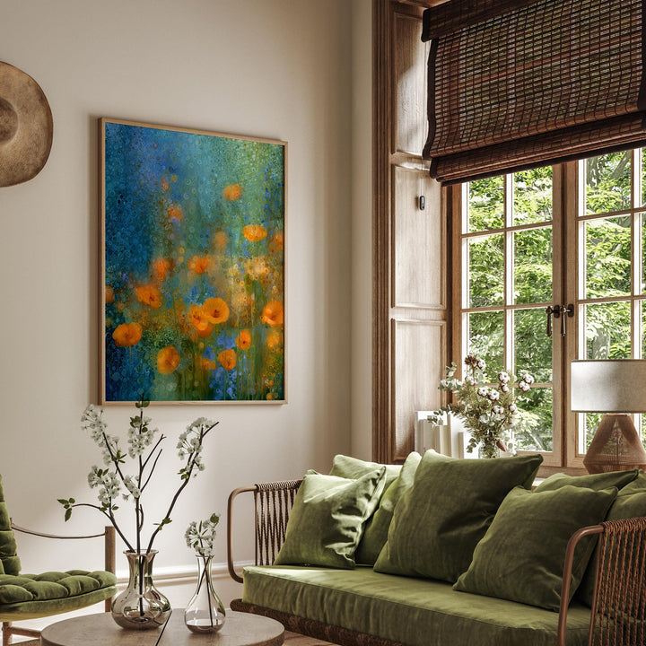 May include: An abstract art print in a wooden frame, depicting orange poppies on a blue and green backdrop. The artwork is displayed in a living room with a green sofa, cushions, and a window with natural light.